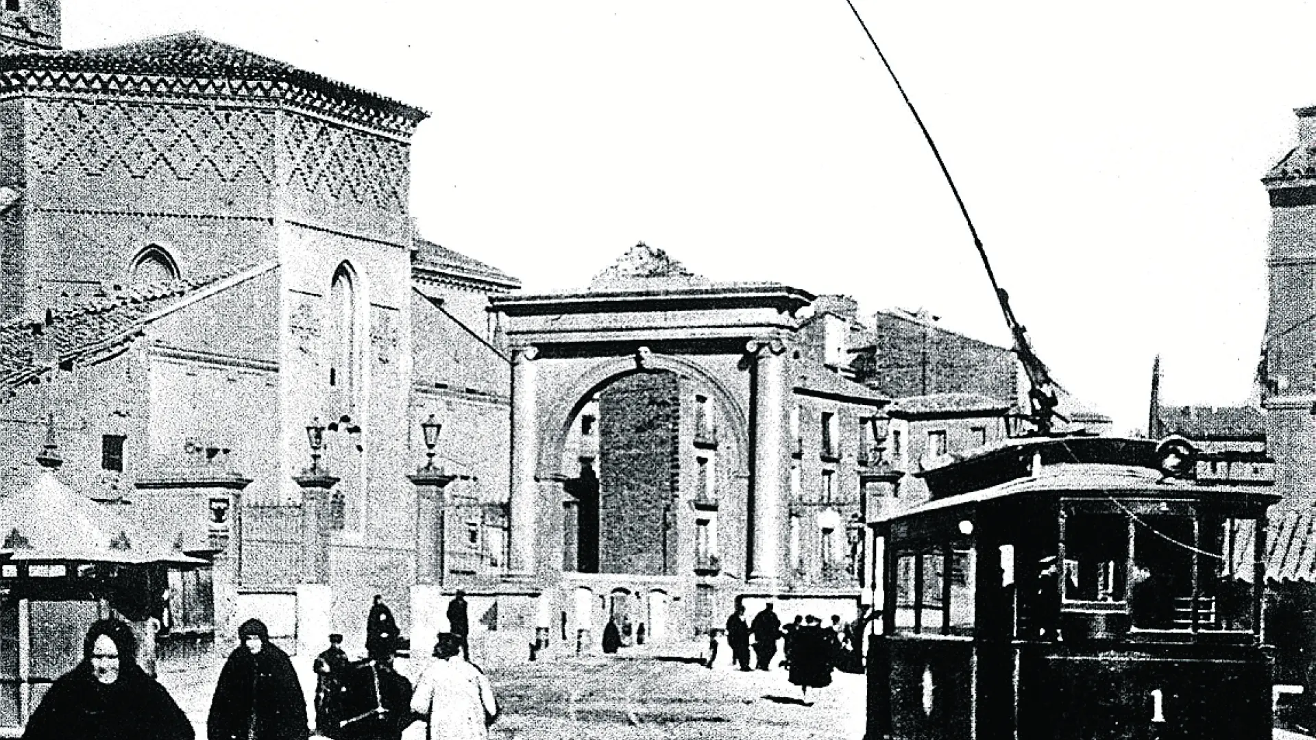 La puerta junto a la Iglesia de San Miguel de los Navarros y el tranvía eléctrico número 1